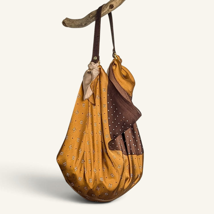 RecloStudio Taschenhenkel aus braunem Kork mit Metallringen, befestigt an einem gemusterten Halstuch als Handtasche